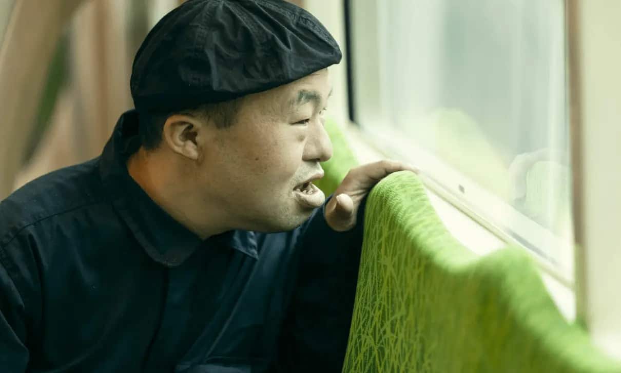 電車内から外の景色を見る中島さんの写真